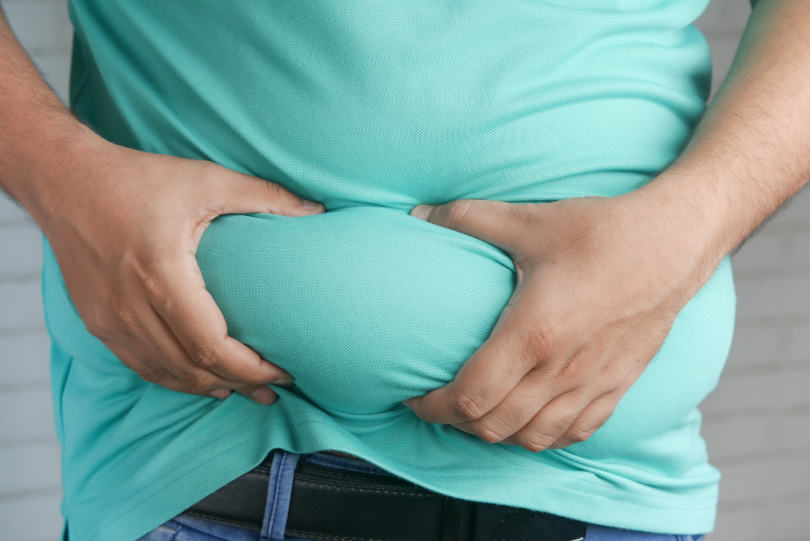 a man holding his stomach with his hands